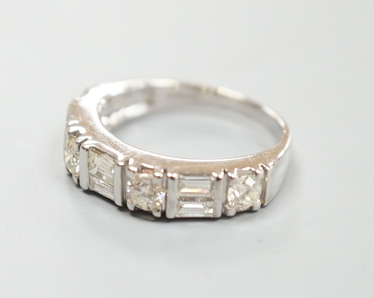 A modern 14ct gold, baguette and round cut diamond set half hoop ring, size K, gross weight 3.9 grams.